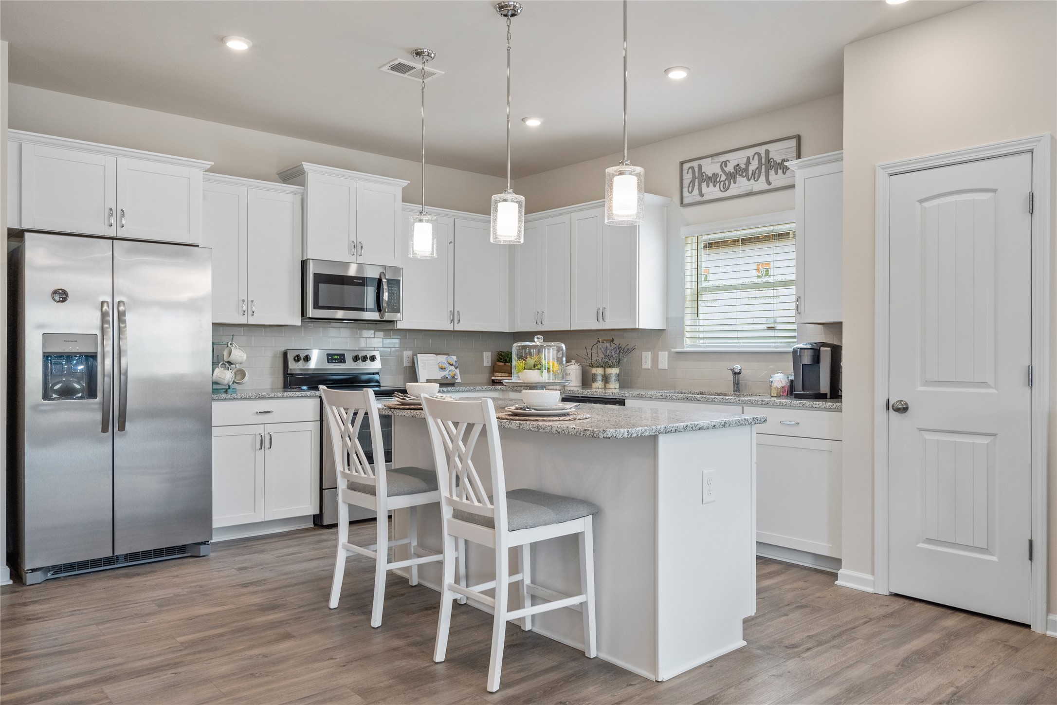 9722 Enclave Ridge Road Willis, TX 77318 - Photo 8 of 20 a kitchen with kitchen island white cabinets and stainless steel appliances