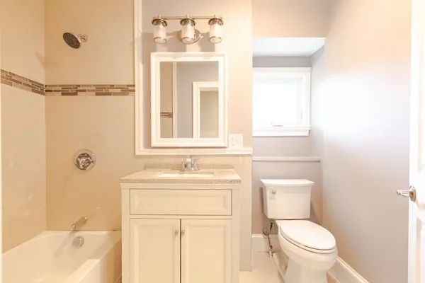 a bathroom with a tub a sink and a window