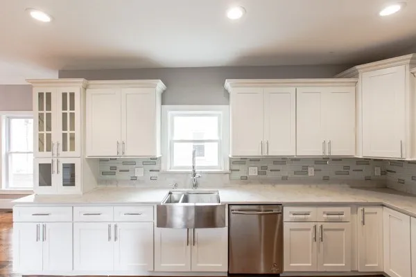 a kitchen with stainless steel appliances granite countertop a sink and dishwasher with white cabinets