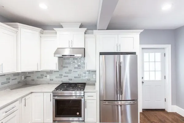 a kitchen with cabinets a refrigerator and a stove top oven