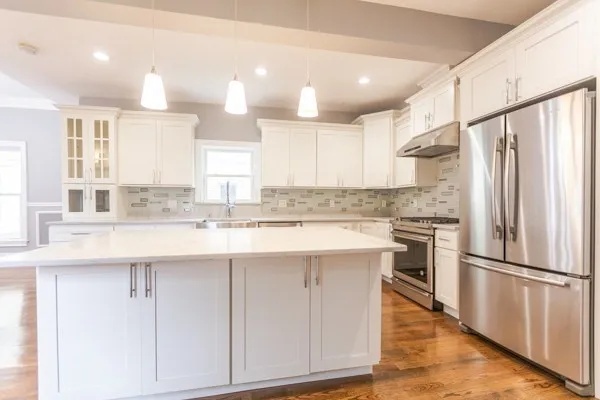 a kitchen with kitchen island granite countertop a sink appliances cabinets and counter space