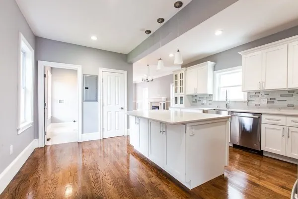 a large kitchen with a lot of counter space and wooden floor