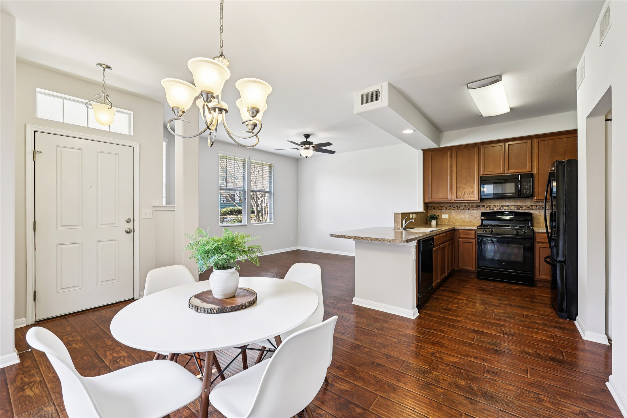 1524 Sanders Kyle, TX 78640 - Photo 8 of 37 a kitchen with kitchen island a dining table wooden floor and a chandelier