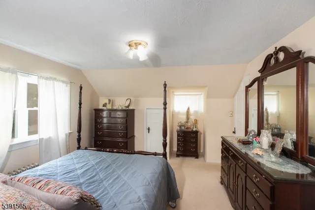 a bedroom with a bed and dresser with mirror