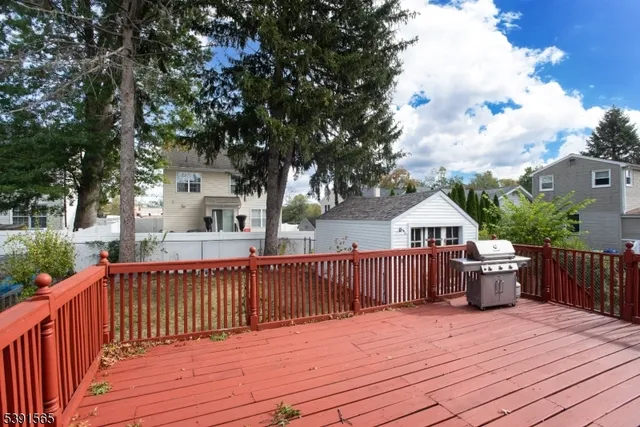 a view of a deck with wooden floor and fence next to a yard