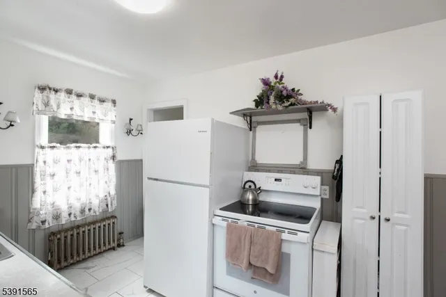 a white kitchen with sink stove and refrigerator