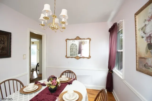 a view of a dining room with furniture a chandelier and wooden floor