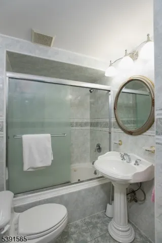 a bathroom with a sink toilet and a mirror