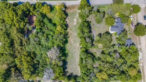 an aerial view of residential house with outdoor space and trees all around