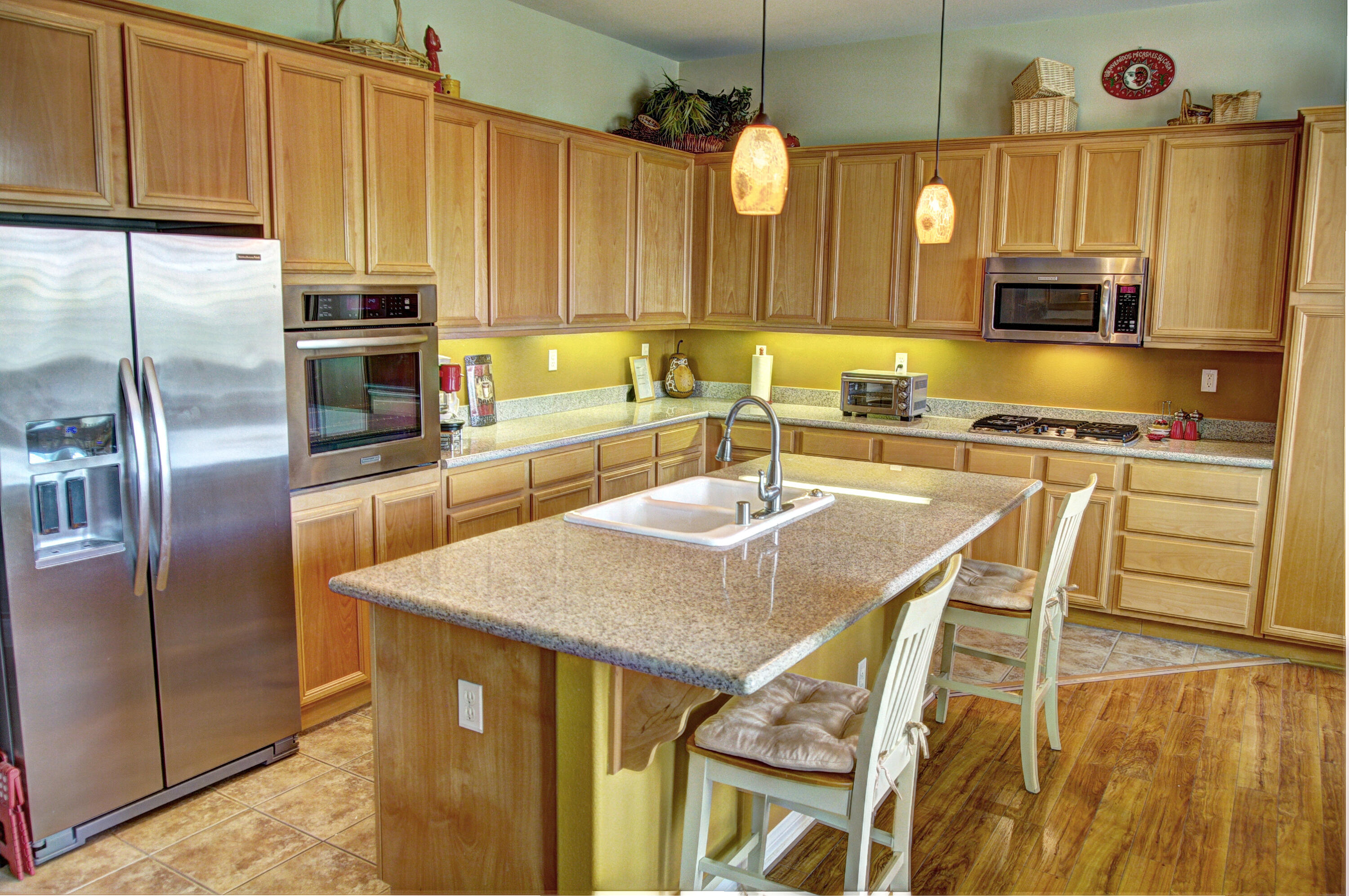 82799 Burnette Drive Indio, CA 92201 - Photo 2 of 36 a kitchen with stainless steel appliances granite countertop a sink a microwave refrigerator and chairs