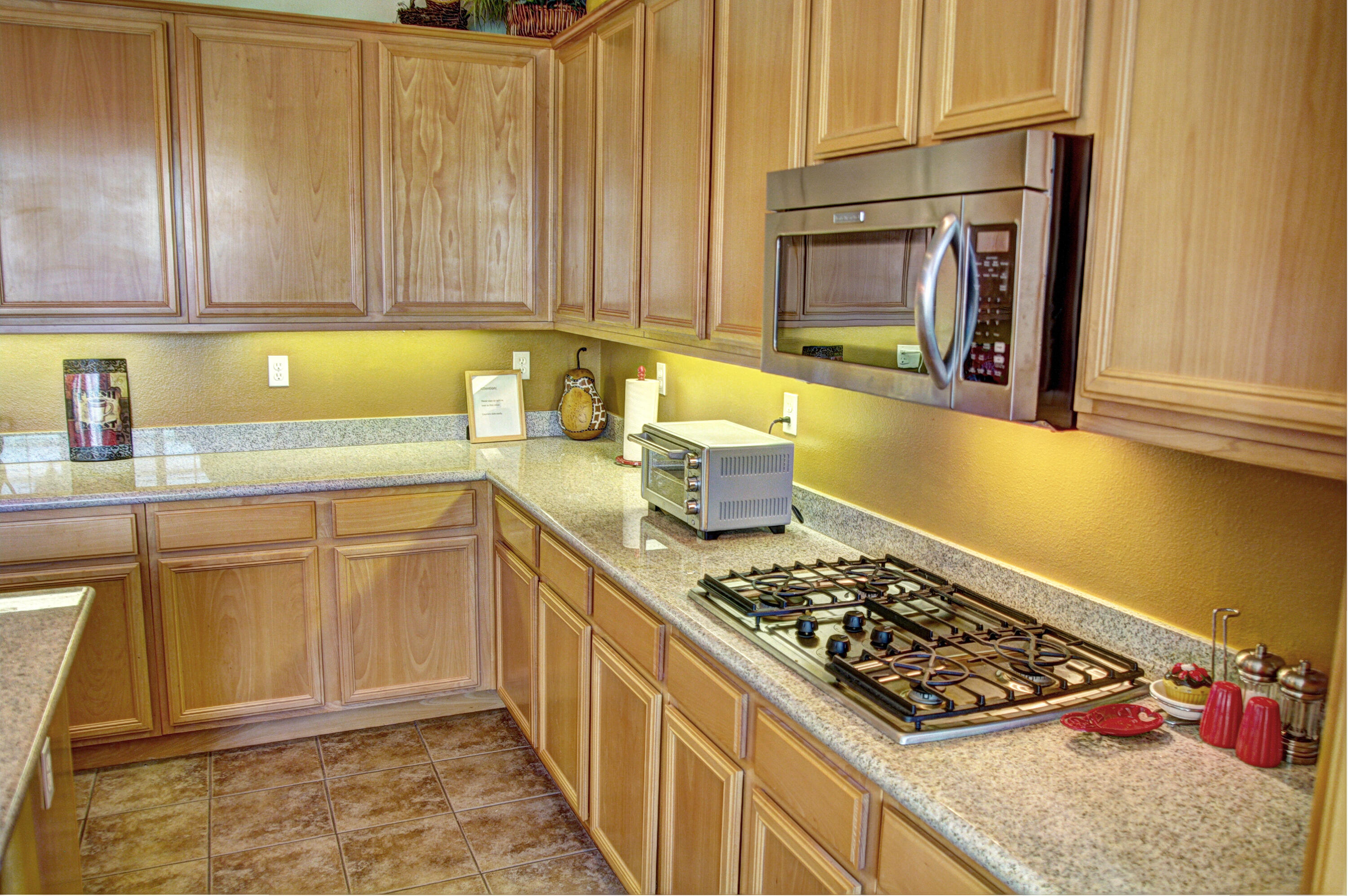 82799 Burnette Drive Indio, CA 92201 - Photo 4 of 36 a kitchen with wooden cabinets and a stove top oven