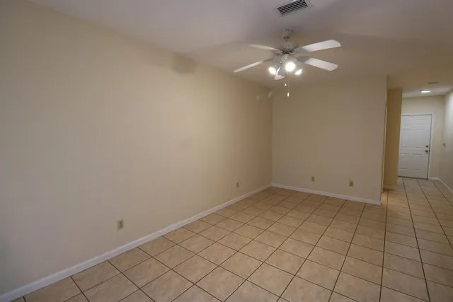 an empty room with a chandelier fan