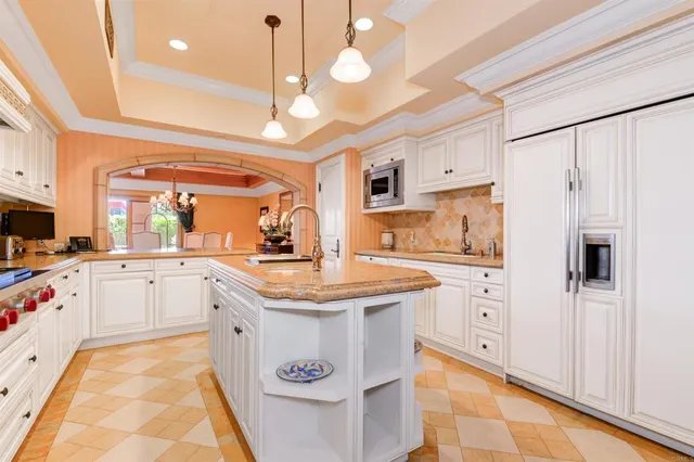 a kitchen with stainless steel appliances granite countertop a sink a stove and refrigerator
