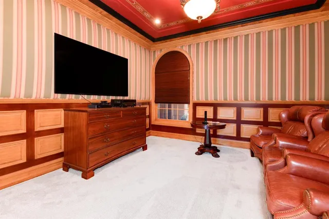 a living room with furniture a flat screen tv a rug and wooden floor