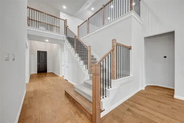 a view of a hallway with wooden floor and stairs