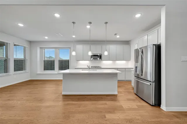 a kitchen with kitchen island a counter top space stainless steel appliances and a window