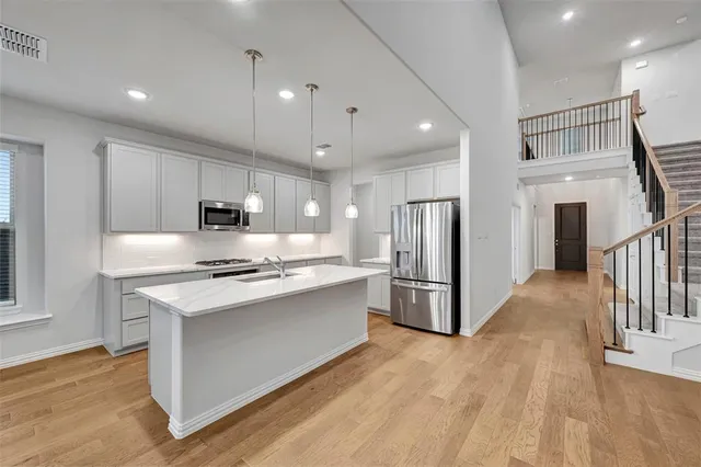 a kitchen with stainless steel appliances a stove refrigerator sink and microwave