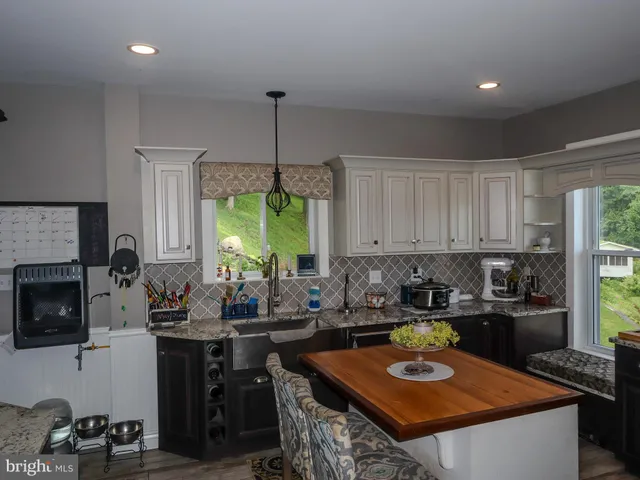 a living room with furniture a chandelier and a wooden floor