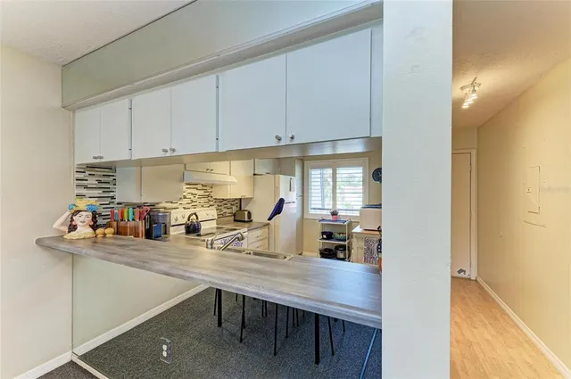 a kitchen with white cabinets and white appliances