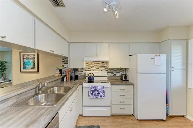 a kitchen with refrigerator and cabinets