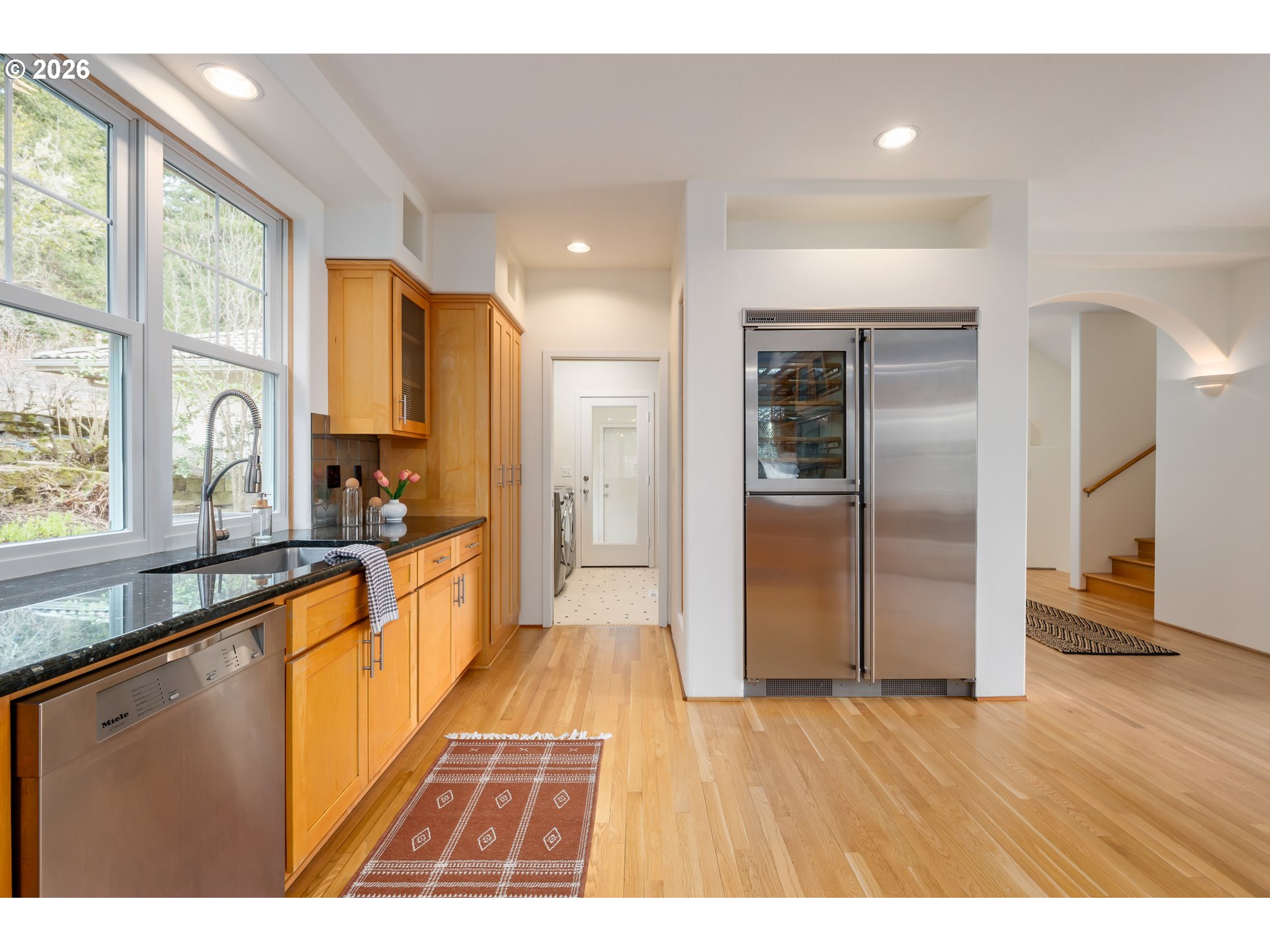4015 Spring Knoll Drive Eugene, OR 97405 - Photo 13 of 48 a large kitchen with granite countertop a refrigerator a sink a stove and white cabinets with wooden floor