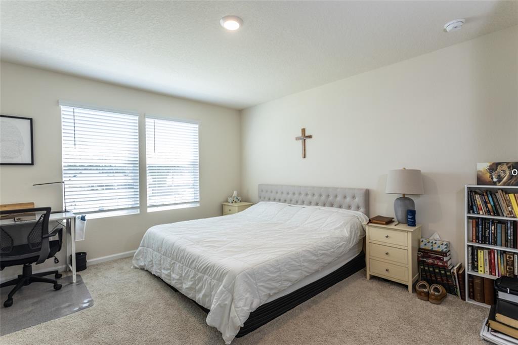 71 Redbud Road Palm Coast, FL 32137 - Photo 14 of 32 a bedroom with a bed and a chair