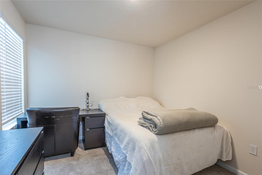 71 Redbud Road Palm Coast, FL 32137 - Photo 19 of 32 a bedroom with a bed and a desk