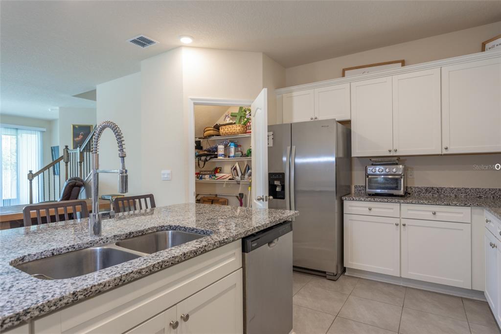 71 Redbud Road Palm Coast, FL 32137 - Photo 4 of 32 a kitchen with stainless steel appliances granite countertop a sink refrigerator and cabinets