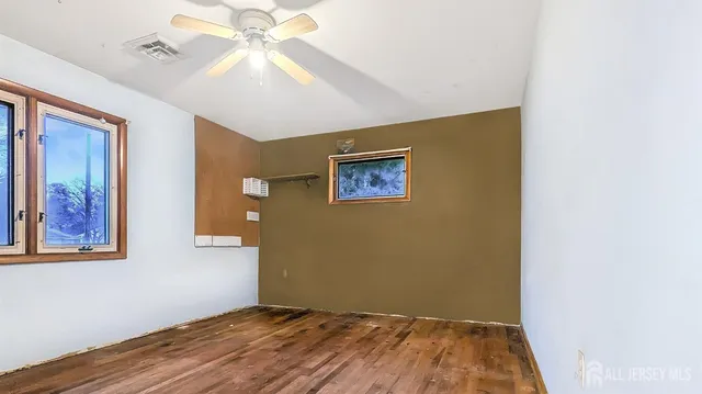a view of a bedroom with a ceiling fan and wooden floor