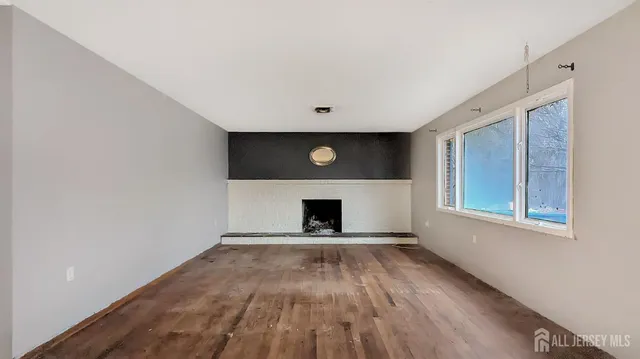 a view of an empty room with window and fireplace
