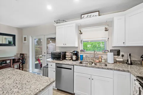 a kitchen with stainless steel appliances granite countertop a sink stove and cabinets