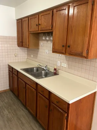 a kitchen with a sink cabinets and wooden floor