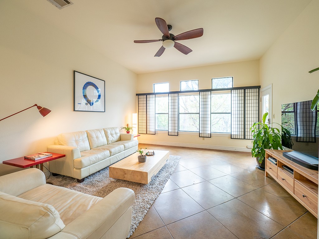 3609 Clawson Road, Unit B Austin, TX 78704 - Photo 4 of 28 Spacious living area featuring high ceilings, a ceiling fan, and large windows with decorative screens