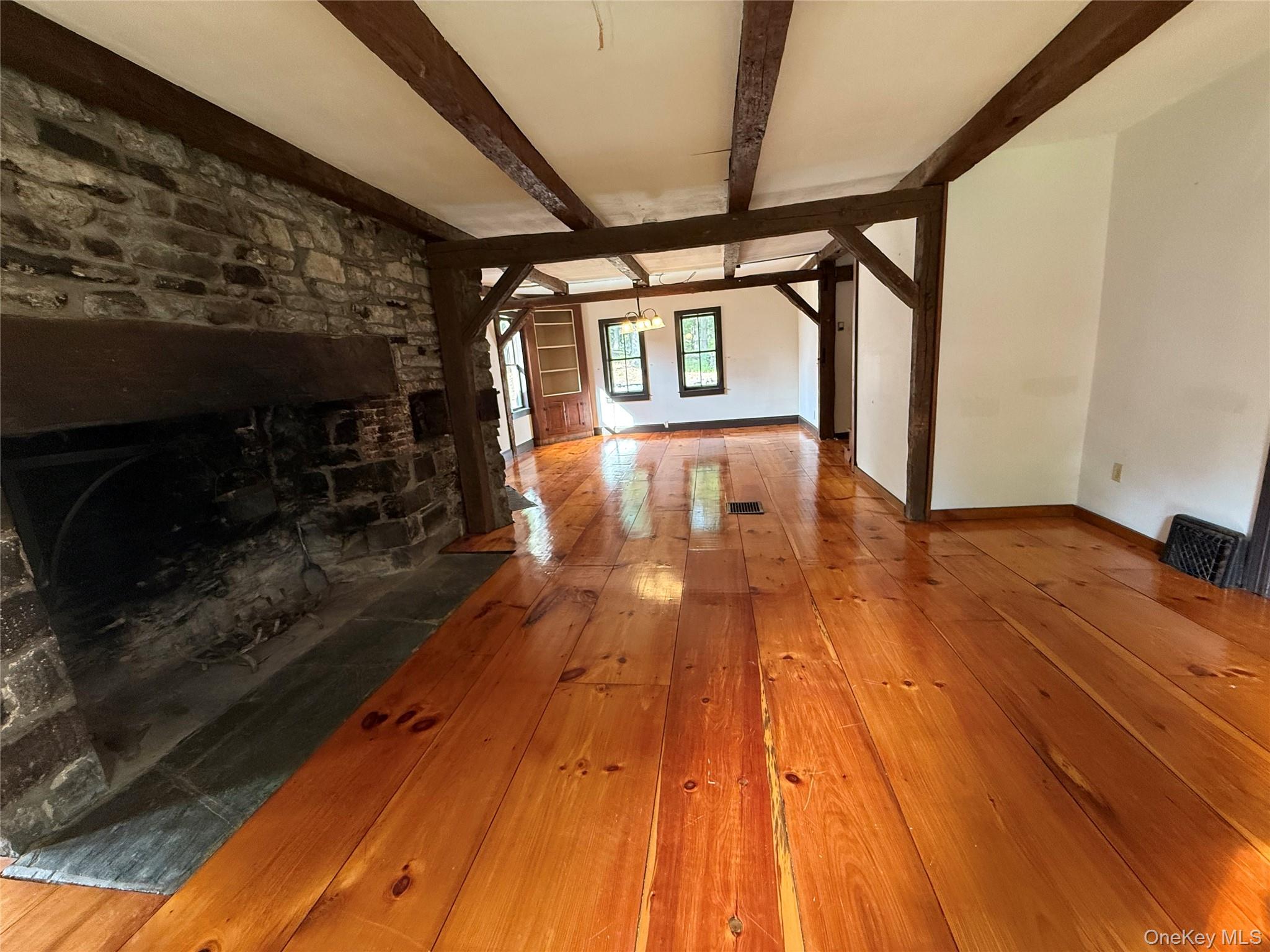 241 White Bridge Road Middletown, NY 10940 - Photo 13 of 29 Unfurnished living room with hardwood / wood-style flooring, beamed ceiling, and a chandelier