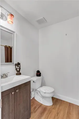 a bathroom with a toilet a sink and mirror
