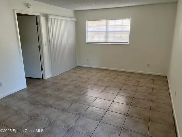 a view of a livingroom with an empty space and a window