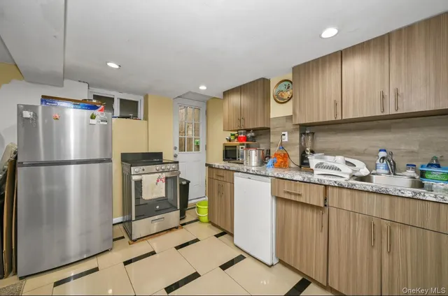 a kitchen with a refrigerator a sink dishwasher and cabinets with wooden floor