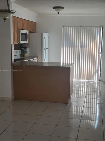 a view of kitchen with granite countertop cabinets