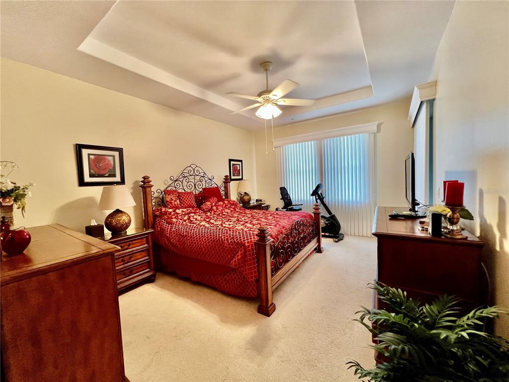 3304 Sunset Key Circle, Unit D Punta Gorda, FL 33955 - Photo 17 of 53 a spacious bedroom with a bed dresser and a chandelier