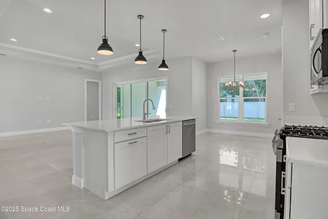 a large white kitchen with a large window