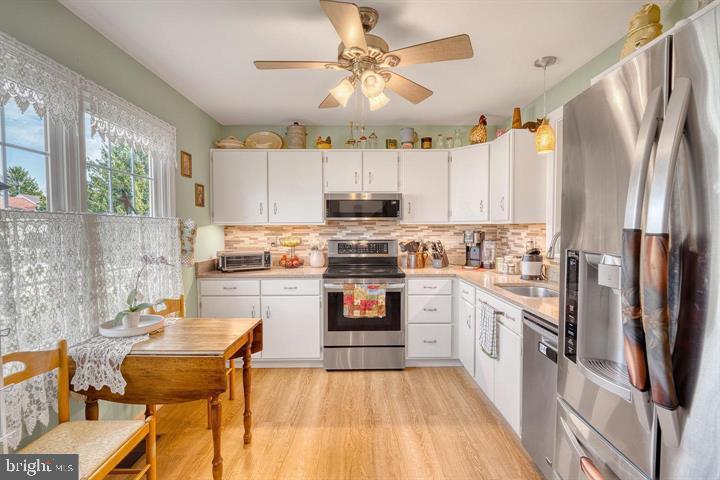 15-4 Cranberry Ridge Reading, PA 19606 - Photo 2 of 19 a kitchen with stainless steel appliances a stove a sink dishwasher a refrigerator and a dining table with wooden floor