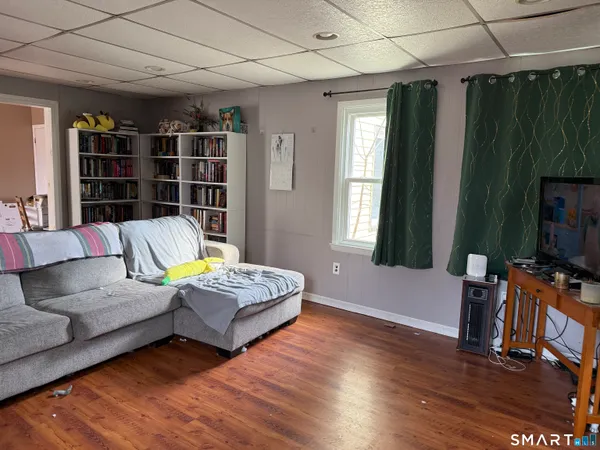a living room with furniture hard wood floor and a flat screen tv