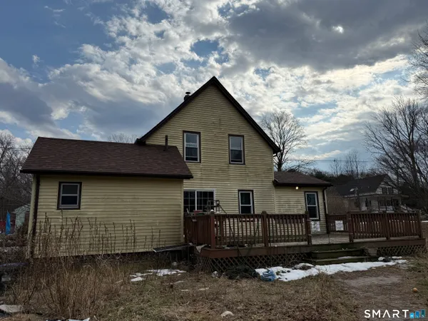 a view of house with a yard and large tree