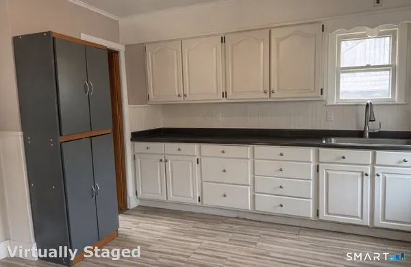a kitchen with a refrigerator and white cabinets