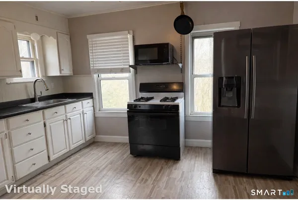 a kitchen with granite countertop a refrigerator stove and microwave
