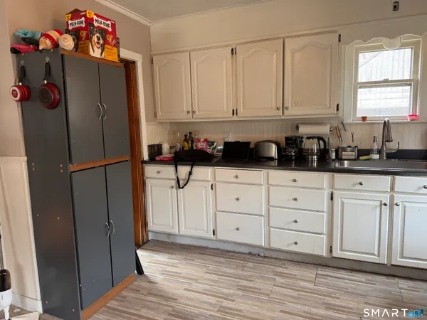 a kitchen with granite countertop white cabinets and refrigerator