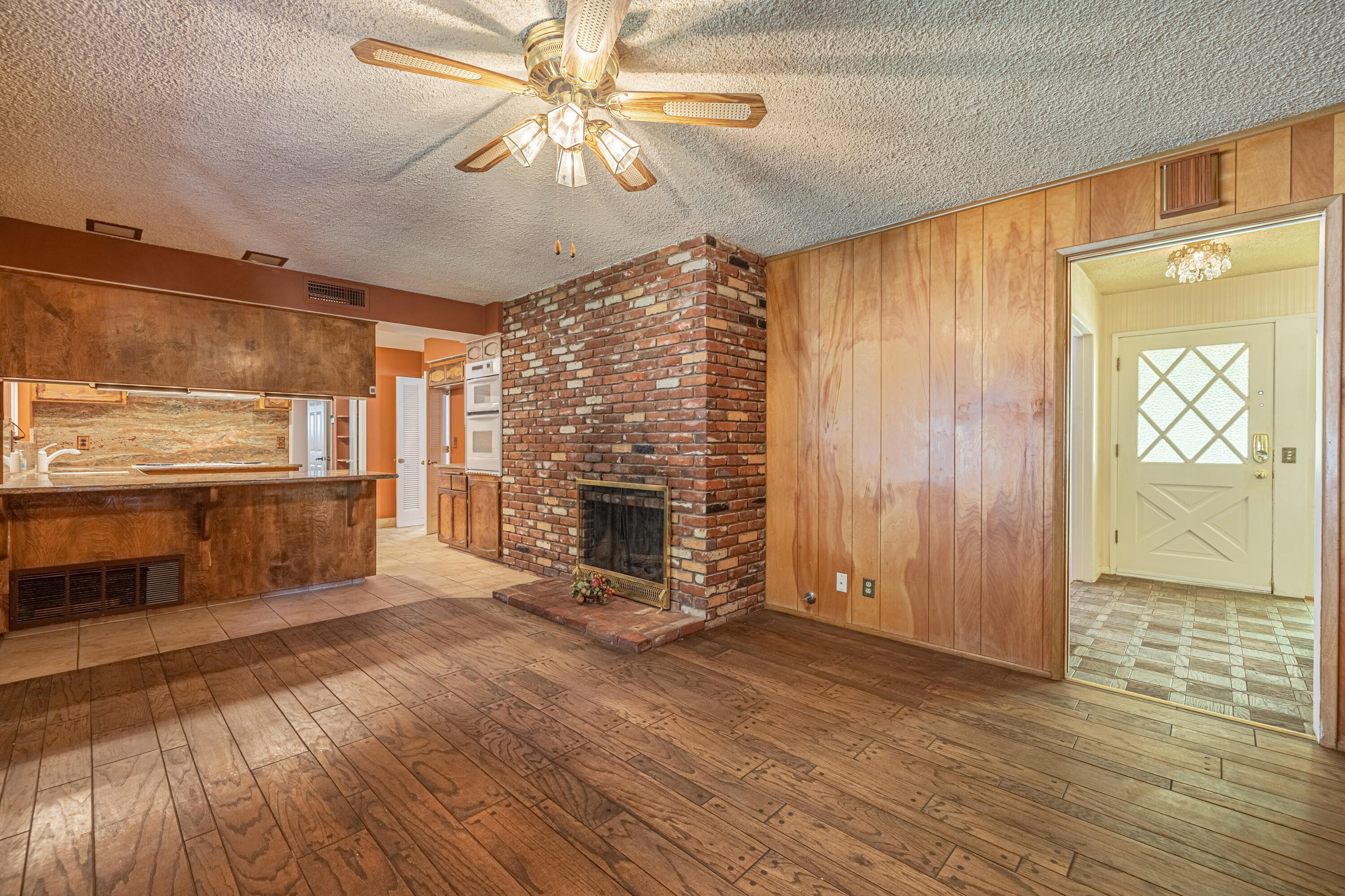 43733 Fenner Avenue Lancaster, CA 93536 - Photo 18 of 48 a view of a livingroom with a fireplace a ceiling fan and wooden floor