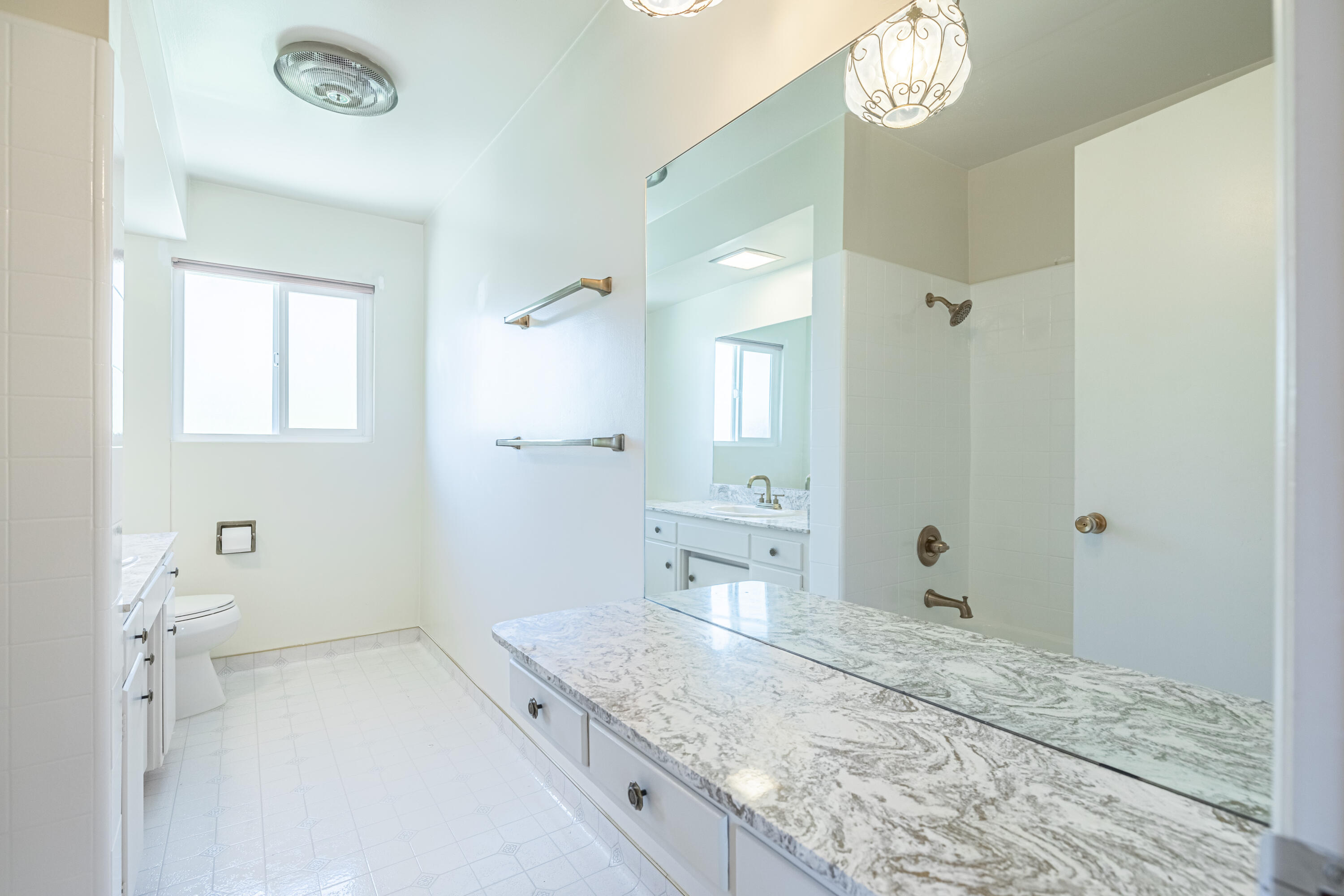 43733 Fenner Avenue Lancaster, CA 93536 - Photo 37 of 48 a spacious bathroom with a granite countertop sink a mirror and a shower