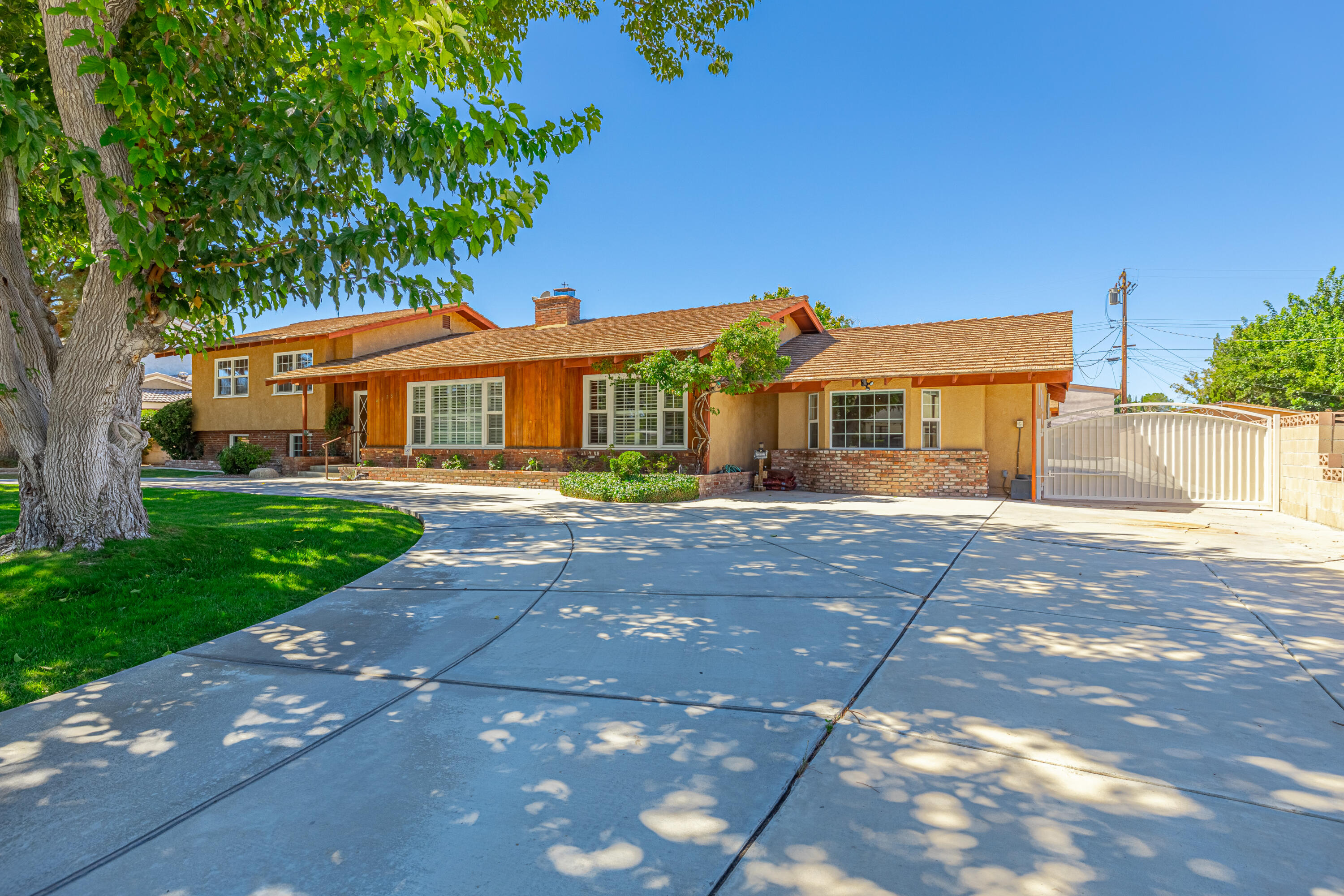 43733 Fenner Avenue Lancaster, CA 93536 - Photo 45 of 48 a front view of a house with a yard and green space