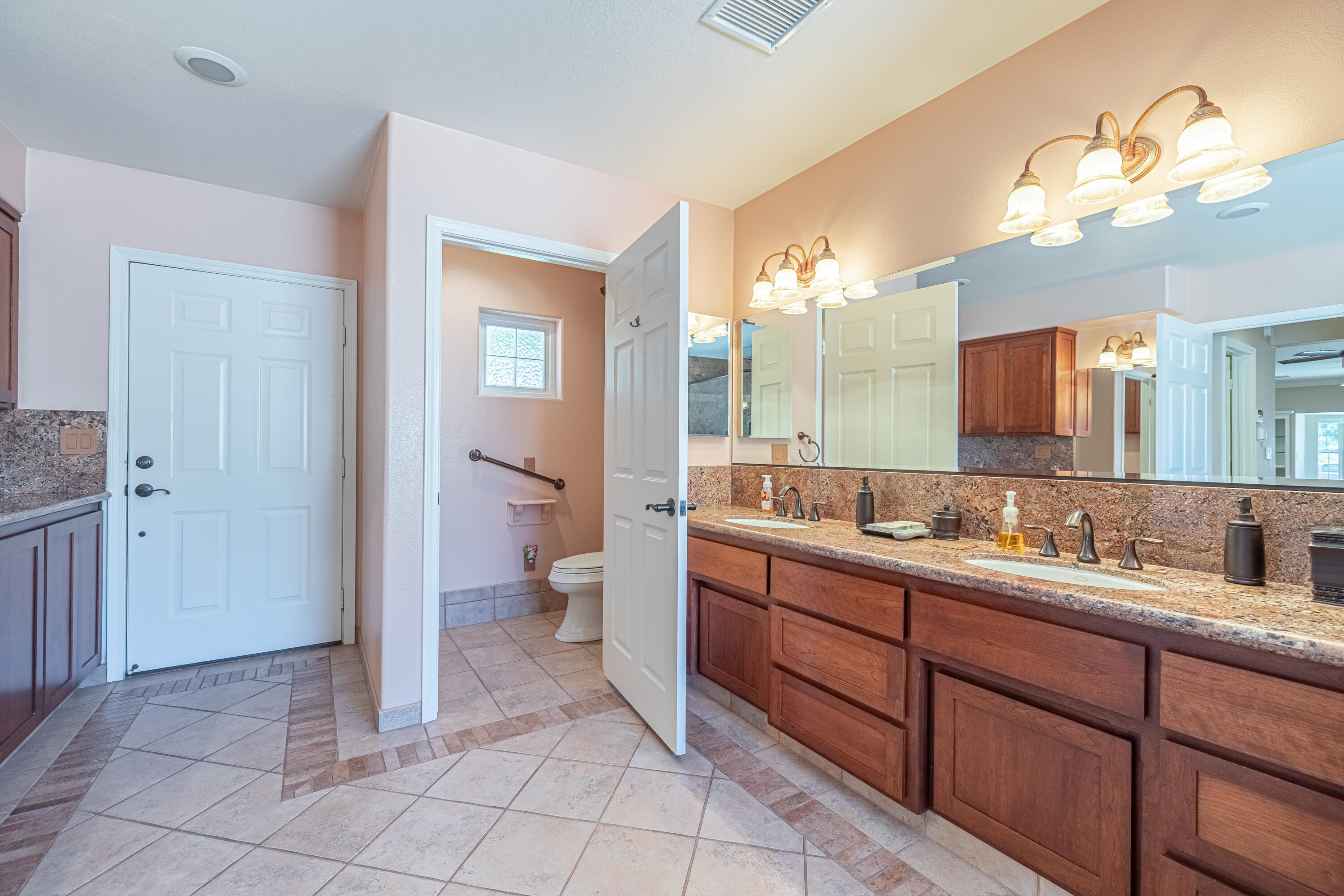43733 Fenner Avenue Lancaster, CA 93536 - Photo 10 of 48 a spacious bathroom with a double vanity sink a toilet and a mirror